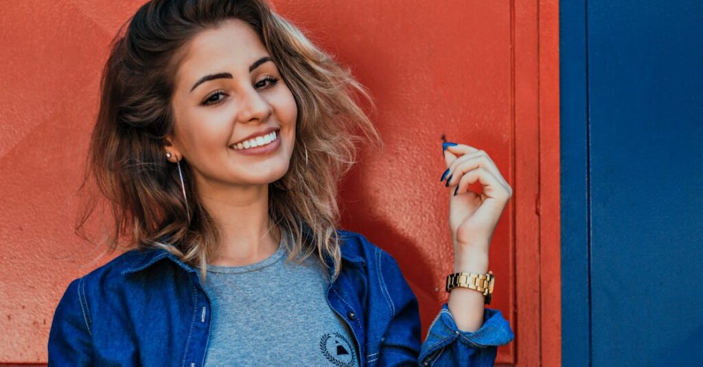 A woman in a denim jacket smiling brightly against a vibrant red and blue background. Best Products for Sustainable Living