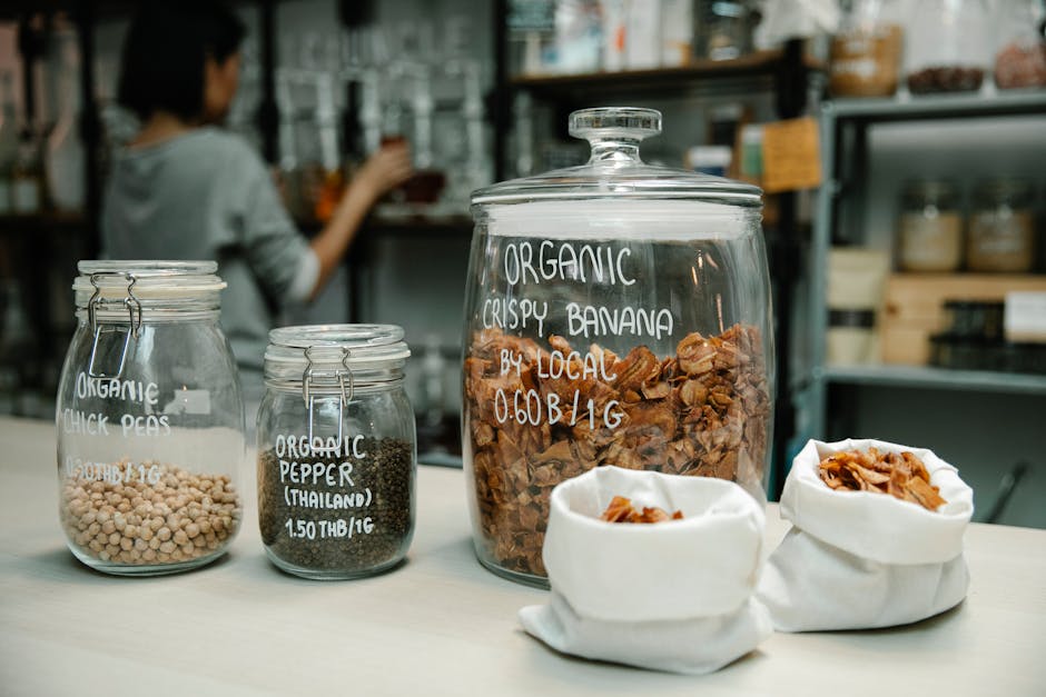 Glass jars with organic chickpeas, pepper, and crispy banana on kitchen counter. Eco-Friendly Kitchen Shopping Guide